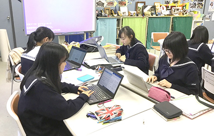 生徒がノートパソコンを使用し、論文を作成しています。
